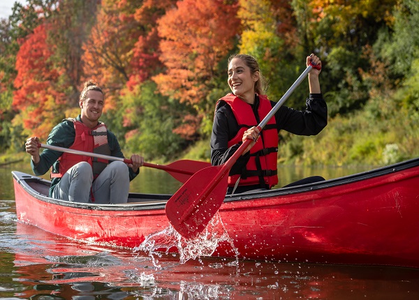 A woman and a man canoeing in a river.