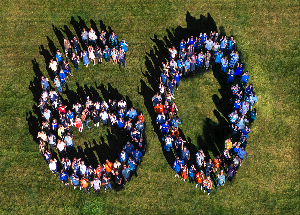 Large group of people forming the number 60